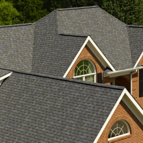 CertainTeed Shingle roofing displayed on a brick home in the color Driftwood.